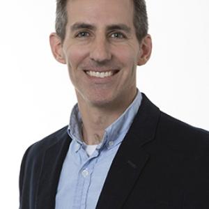 J. Etress smiling in a black blazer
