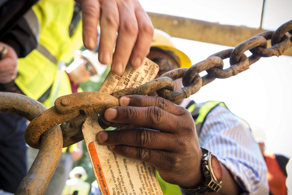 Hands adding a tag to a chain, photo