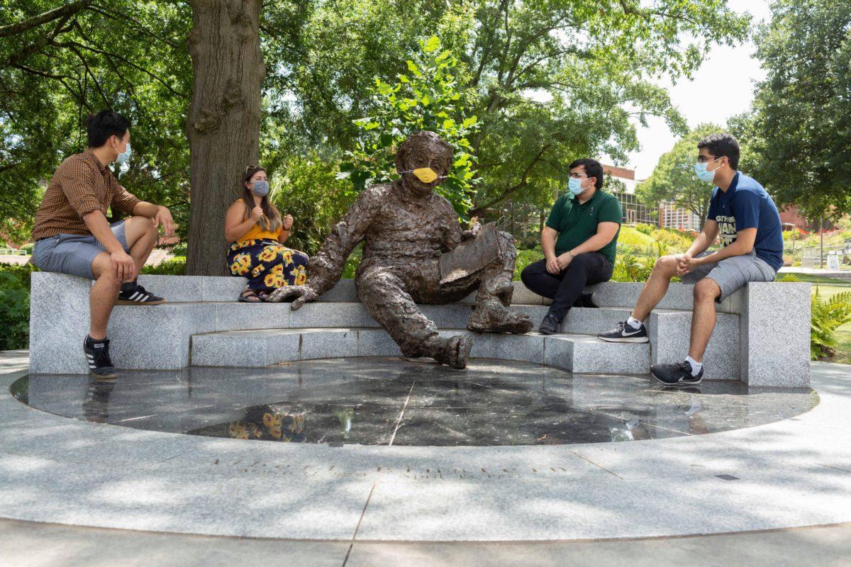 Students sitting in front of the Einstein statue, photo