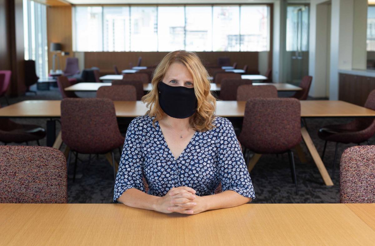 Staff member at a desk with protective face covering, photo