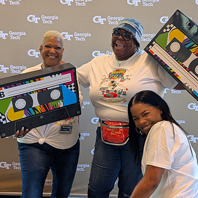 staff in front of GT step and repeat banner